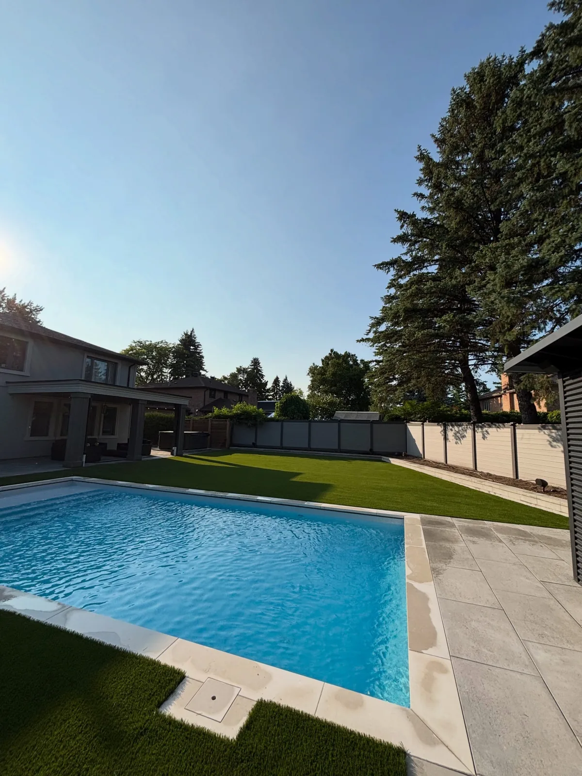 Artificial grass installed around a backyard pool in Caledon